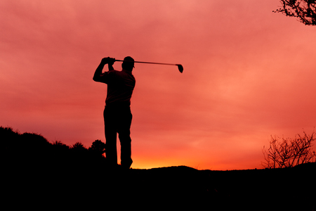 Golfer Silhouetted in Sunsetの写真素材