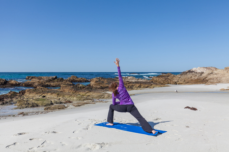 Woman Practicing Yoga on the Beachの写真素材