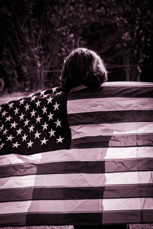 Boy with American flag on his shoulder. Black and white photo.