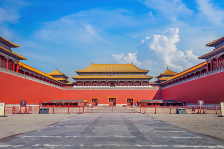 Front view of the Meridian Gate of the Forbidden City in Beijing, showing red walls and golden roofs under a bright blue sky.の写真素材