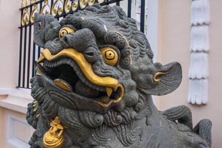 Face Lion guard statue. taken at the entrance of Chinese temple in Malaysia.の写真素材