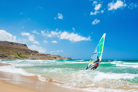Surfing on the sea coast. Tropical beach with turquoise water and big waves. Crete island, Greece.の写真素材