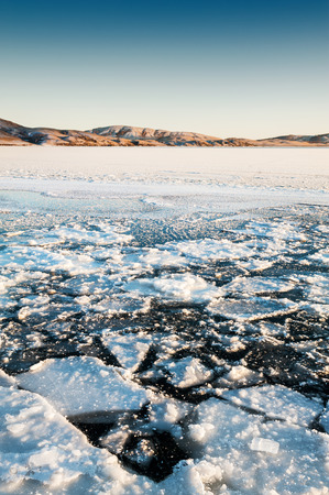 Beautiful winter lake with ice at sunset. Winter landscapeの写真素材