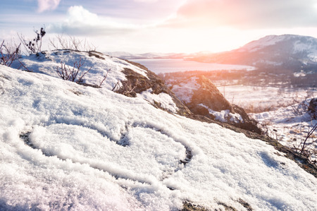 Heart on the snow. Winter landscape in the mountain at sunsetの写真素材