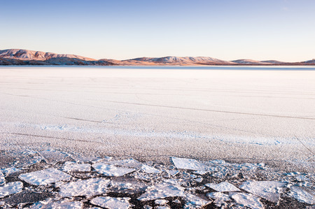 Ice and snow on the lake at sunset. Beautiful winter landscape. Creative toning effectの写真素材