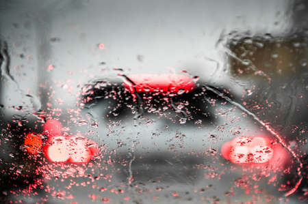 Car lights through the wet windshield. Bokeh abstract lights background. Soft focusの写真素材