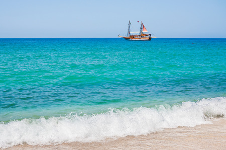 Sea beach in Alanya, Turkey. Tourist ship by the sea. Beautiful summer landscape.の写真素材