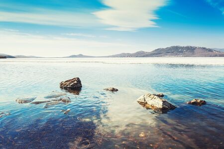 Beautiful spring landscape with ice on the lake. Creative toning effect