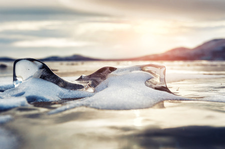 Winter landscape with ice on the lake at sunset. Small depth of sharpness. Creative toning effectの写真素材