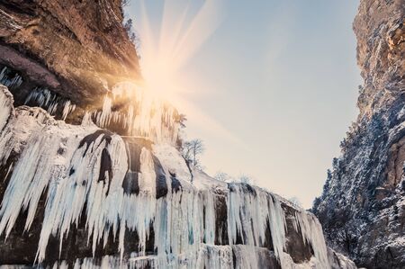 Frozen waterfall at sunset. Beautiful winter landscape. Chegem gorge, Caucasus, Russian Federation. Creative toning effectの写真素材