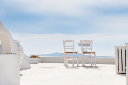 Two chairs on the terrace. White architecture on Santorini island, Greece. Summer holidaysの写真素材