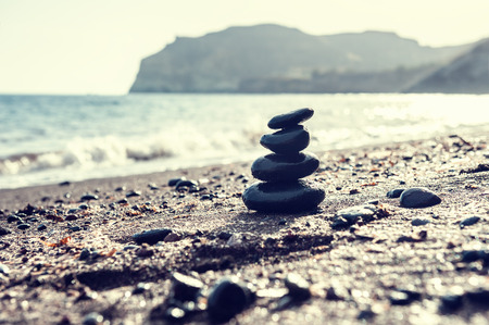 Stones pyramid on the beach. Zen and harmony. Selective focus. Vintage filter, retro effectの写真素材