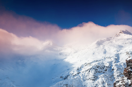 Winter snow-covered mountains at sunset. Creative toning effect. Beautiful winter landscapeの写真素材