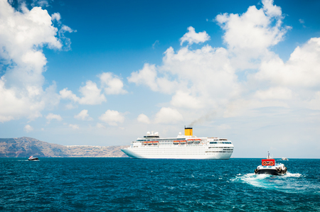 Cruise ship at sea. Turquoise sea and blue sky with clouds. Santorini island, Greece.の写真素材