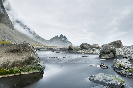 Fantastic coast of the Atlantic ocean with black volcanic sand and mountain view. South of Icelandの写真素材