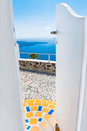 View of the sea through the open door. Beautiful landscape with sea view on Santorini island, Greece. Selective focusの写真素材