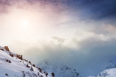 Snow-covered mountains at sunset. Beautiful winter landscapeの写真素材