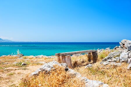 Bench on the sea coast. Selective focus. Beautiful landscape with sea view. Crete island, Greeceの写真素材