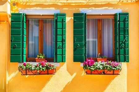 Yellow house and window with green shuttersの写真素材