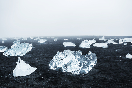 Ice on the black volcanic sand. Jokulsarlon black beach in Icelandの写真素材