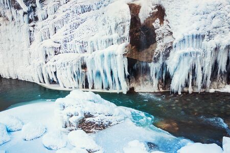 Frozen waterfall in the mountains. Beautiful winter landscape.