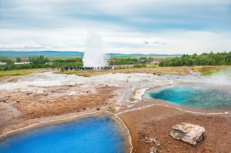 Blue thermal lake Blesi and eruption of Strokkur Geysir, Golden circle route in Icelandの写真素材