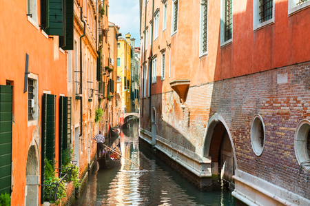 Scenic canal with gondolas and colorful buildings in Venice, Italyの写真素材
