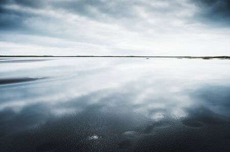 Sky reflected in the water. Beautiful coast of the Atlantic ocean. South Iceland
