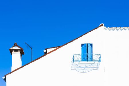 White wall of house with blue window against the blue sky. Colorful houses in Burano island near Venice, Italyの写真素材