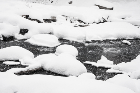 Mountain river during snowfall. Beautiful winter snow landscapeの写真素材