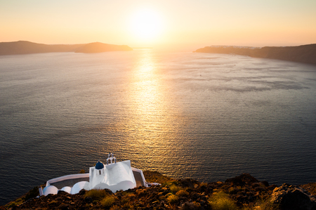 Beautiful church on the sea coast at sunset. Santorini island, Greece.の写真素材