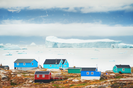 Colorful houses and bay with icebergs in Saqqaq village, western Greenlandの写真素材