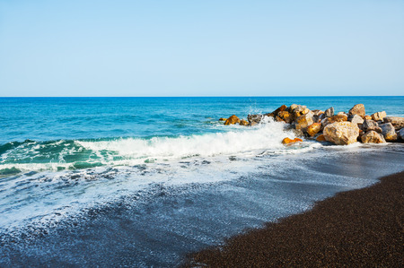 Beautiful beach with black volcanic sand in Perissa, Santorini island, Greece. の写真素材