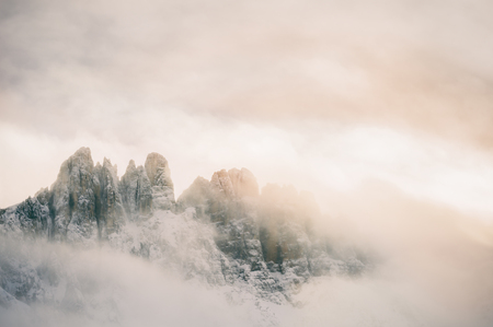 Mountain peaks in the clouds at sunset. Dolomites, Val di Fassa, Italyの写真素材