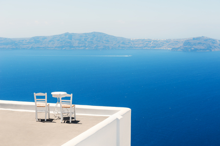 Two chairs on the terrace with sea views. Santorini island, Greece. Travel and vacation backgroundの写真素材