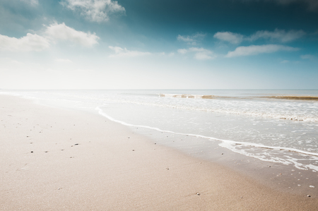 Sandy beach and blue sky with clouds. Coast of the North sea in the Netherlandsの写真素材