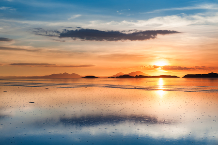 Mirror surface on the salt flat Salar de Uyuni at sunset, Altiplano, Boliviaの写真素材