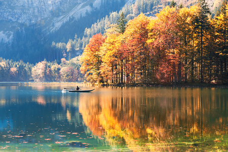Boat floating on the lake in Austrian Alps. Hinterer Langbathsee lake, autumn landscapeの写真素材