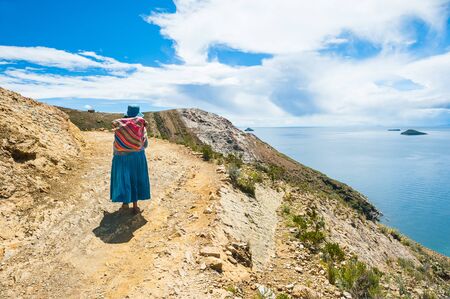 Bolivia - March, 23, 2017. Local woman in national clothing walking on Island of Sun (Isla del Sol) on Titicaca lake, Boliviaのeditorial素材