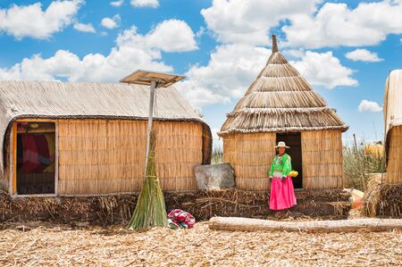 Titicaca lake, Puno, Peru - March, 20, 2017. Woman in traditional dresses on Uros floating islands on Titicaca lake in Puno, Peru, South Americaのeditorial素材