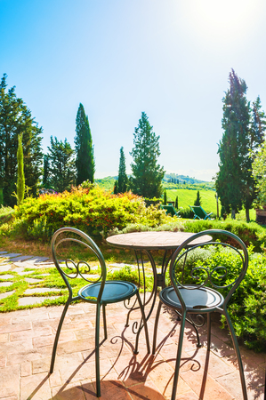 Two chairs and table in the patio of a country house. Tuscany landscape, Italyの写真素材