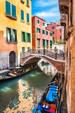 Scenic canal with bridge and colorful buildings in Venice, Italy.の写真素材