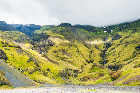 Green mountains with waterfalls in southern Icelandの写真素材