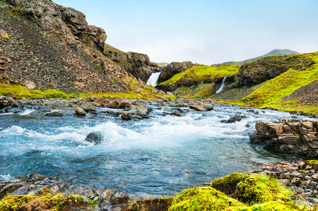 Waterfall in the mountains, eastern Iceland. Beautiful summer landscapeの写真素材