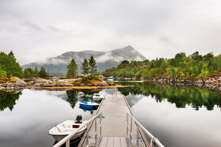 Foggy morning on the coast of fjord in Norway. Summer landscapeの写真素材