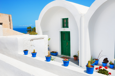 Flowers in the pots in courtyard of the house. Traditional greek architecture on Santorini island, Greece.の写真素材