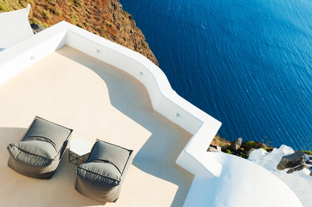 Two chaise lounges on the terrace with sea view. Santorini island, Greeceの写真素材