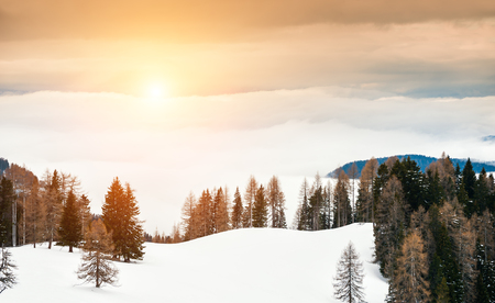Fog in the snow-covered mountains at sunset. Beautiful winter landscapeの写真素材