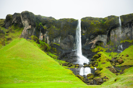 Beautiful waterfall in eastern Iceland in foggy day. Summer landscapeの写真素材