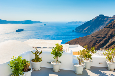 Flowers on the terrace with sea view. White architecture on Santorini island, Greece.の写真素材
